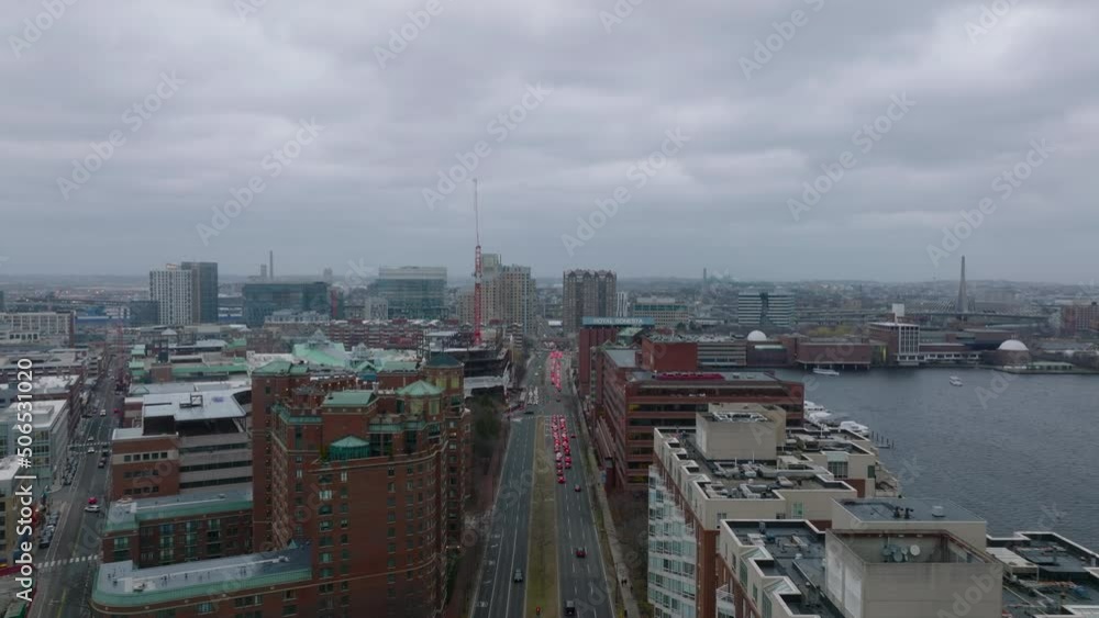 Aerial view of modern urban borough on riverside. Forwards fly above busy road. Row of cars with brake lights on. Boston, USA Aerial view of modern urban borough on riverside. Forwards fly above busy road. Row of cars with brake lights on. Boston, USA