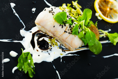Merluza in French recipe. Braise hake fillet 250 gr. in white wine, cream, with black pepper and Herbes de Provence for 20 minutes. Serve with potatoes, lettuce leaves and lemon chips. photo