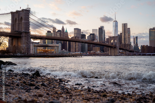 Peble beach in Dumbo Brooklyn, New York downtown skyline. Sunset with few clouds, east river. Brooklyn bridge