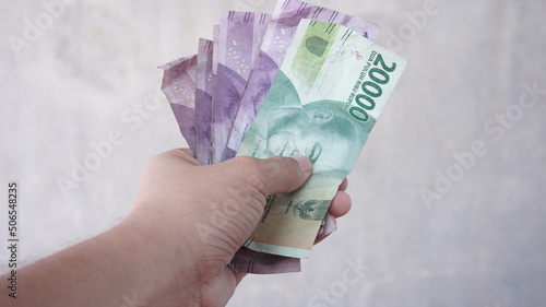 Rupiah banknotes held in hand photo