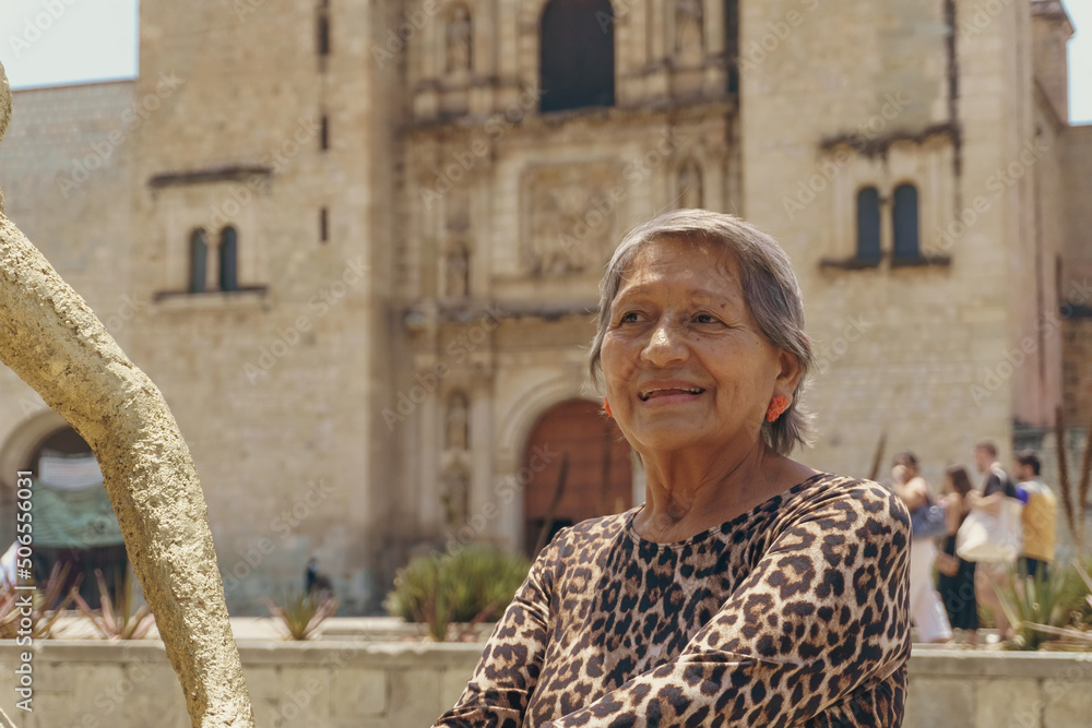 portrait of an older woman smiling outside the santo domingo temple in oaxaca portrait of an older woman smiling outside the santo domingo temple in oaxaca