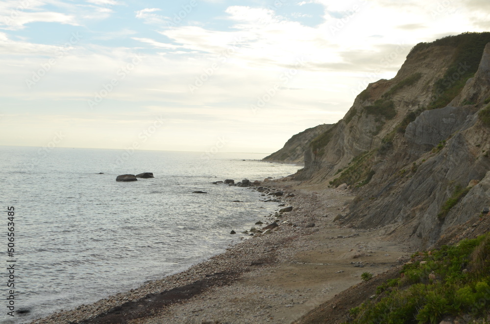 pretty sunset on the beach with sharp rocky cliffs and curving coastline new England beauty pretty sunset on the beach with sharp rocky cliffs and curving coastline new England beauty