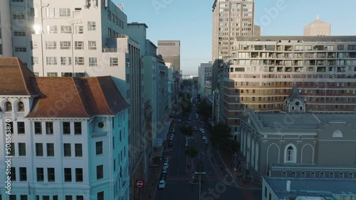 Fly above street in city centre. Church and office of apartment buildings. Cars parking along road. Cape Town, South Africa