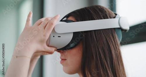 Close up of young woman from left side putting on vr goggles