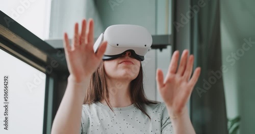 Close up of woman wearing vr goggles and reaching toward lens direction with hands