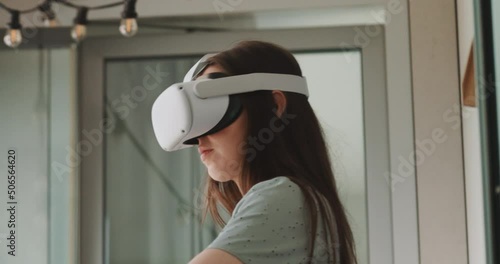 View of young woman wearing virtual reality goggles and looking around
