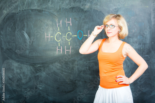 Obraz na plátne blond student girl wearing orange blouse, long white skirt and glasses is standi