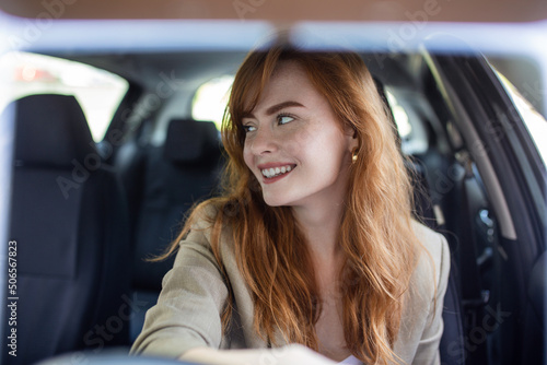 Beautiful young woman driving her new car at sunset. Woman in car. Close up portrait of pleasant looking female with glad positive expression, woman in casual wear driving a car © Graphicroyalty