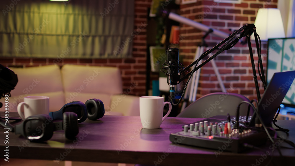 Nobody in podcast home studio with microphone boom arm and audio recording professional mixer on desk. Empty internet online radio setup for producing podcasts for social media. Nobody in podcast home studio with microphone boom arm and audio recording professional mixer on desk. Empty internet online radio setup for producing podcasts for social media.