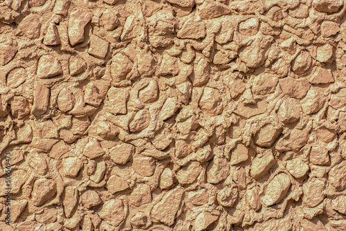 A fragment of a plastered stone wall on a spring day