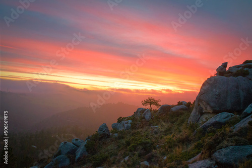 Orange sunset over the mountains covered with pine forests and granite rocks