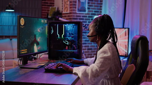 Obraz na plátně African american gamer girl using pc gaming setup playing multiplayer space shooter simulation having a good time in home living room