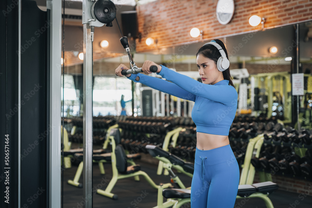 Fototapeta premium Muscular fit woman exercising. Fitness woman doing exercise, athletic girl workout in gym. Concept of healthy lifestyle
