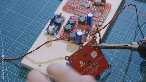 Soldering is done on the microchips in the factory with a soldering machine. electronic working hands.