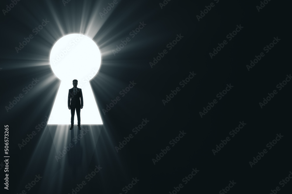 Obraz premium Backlit male standing in bright keyhole opening on dark background with mock up place and light rays. Dream, future and opportunity concept.