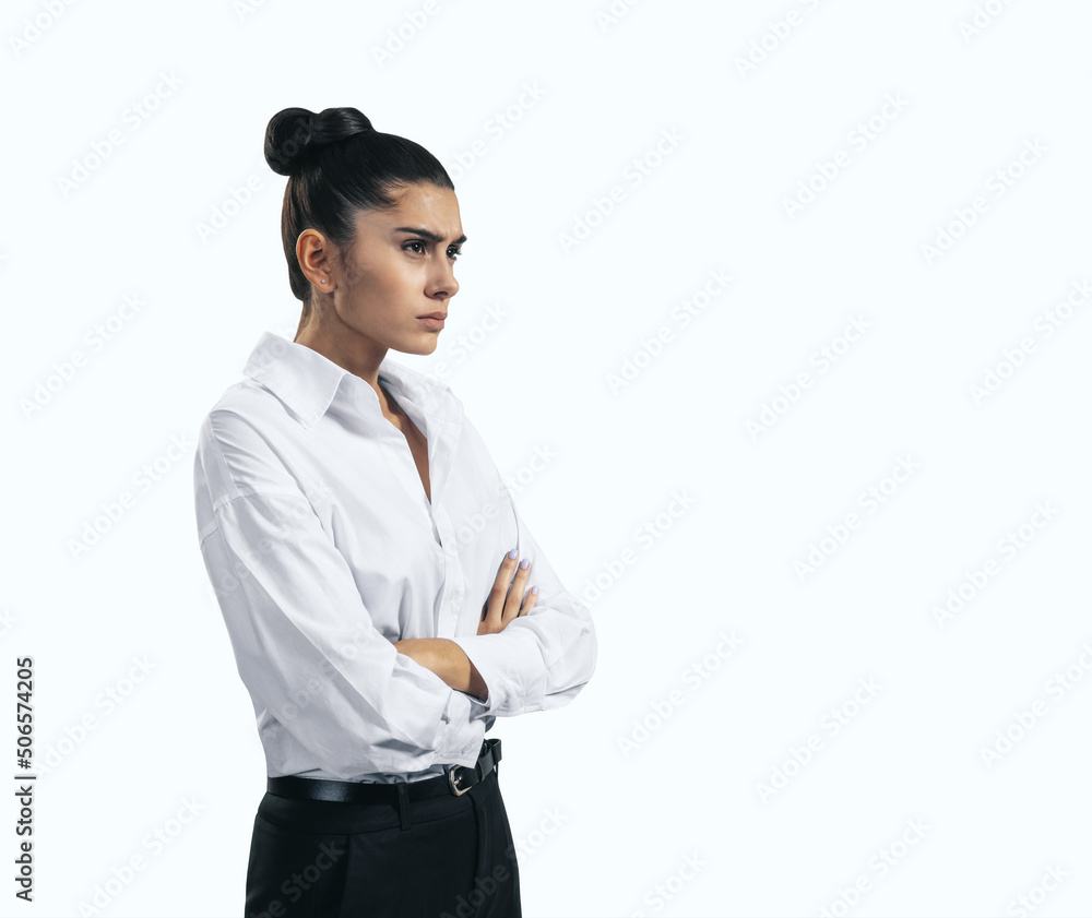 Resentment and unpleasant emotions concept with stressed young woman in white shirt crossing her arms isolated on light background, close up Resentment and unpleasant emotions concept with stressed young woman in white shirt crossing her arms isolated on light background, close up