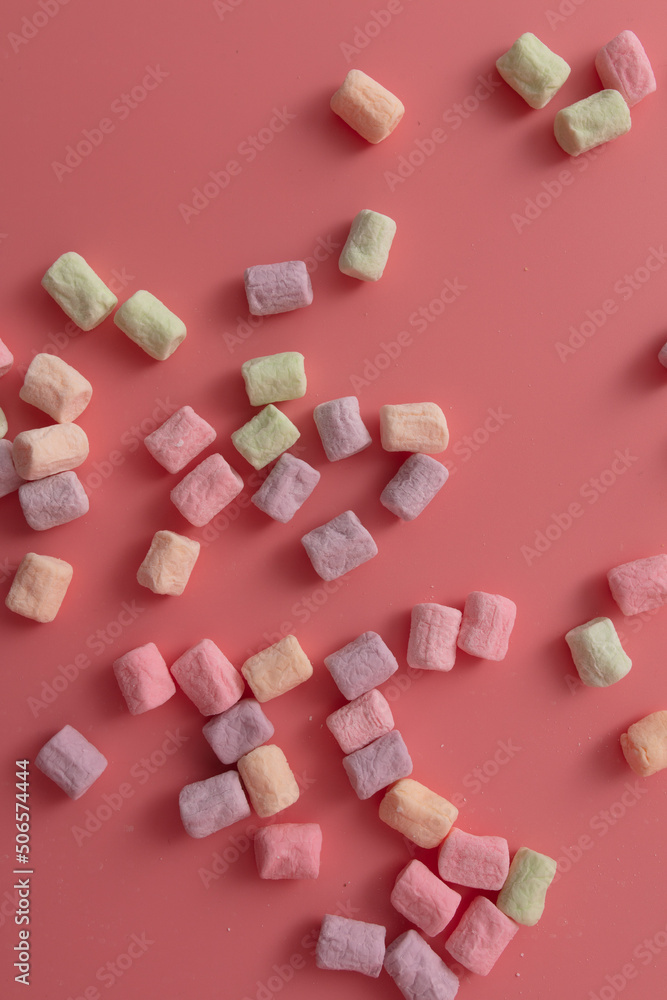 Multicolored candies on a pink background. Close-up Multicolored candies on a pink background. Close-up