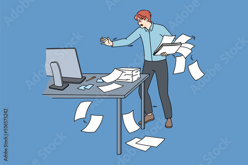 Clumsy employee collect scattered paperwork in office. Awkward tired male worker manage paper documents at workplace. Mess and chaos at work. Flat vector illustration. 