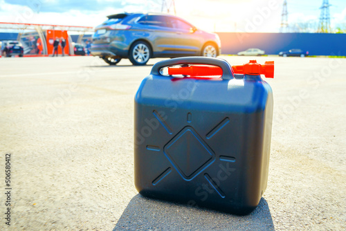 Plastic fuel can is on the ground. Fuel reserve in jerrycan. Lack of petrol or diesel at gas stations concept.