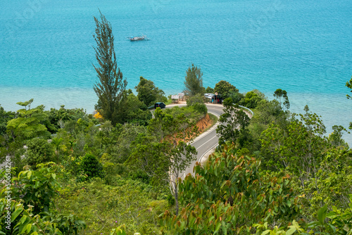 The curve road to Mandeh, South Pesisir, West Sumatera located between cliff and sea with blue sea background photo
