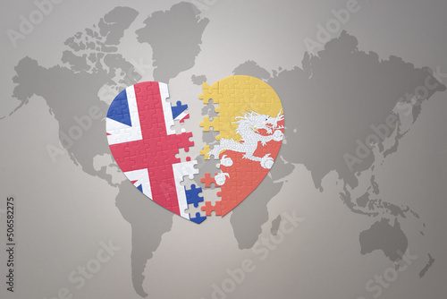 puzzle heart with the national flag of bhutan and great britain on a world map background. Concept.
