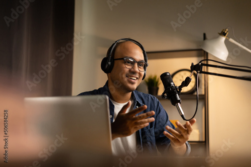Young asian man host streaming podcast with condenser microphone work on laptop at small broadcast home studio Fototapet