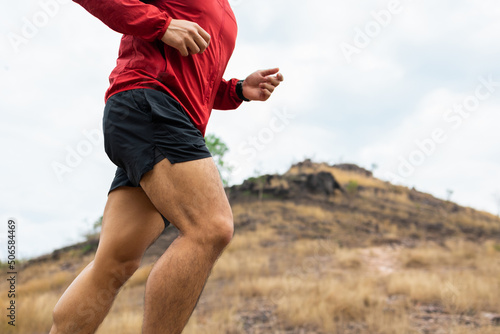 Trail runner man running on rocky mountain. Athlete jog exercising outdoor for healthy. Confident and powerful marathon man running workout and cardio. Sport and Lifestyle concept.