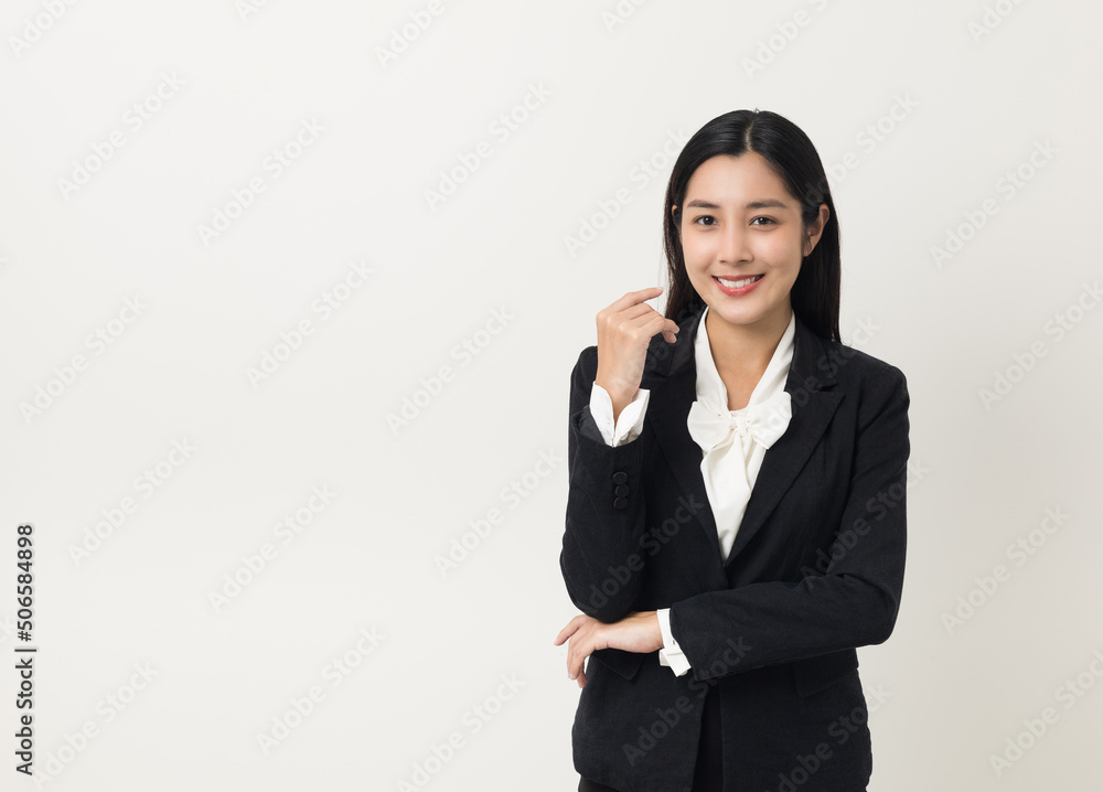 Young asian business woman smiling to camera standing pose on isolated white background. Female around 25 in suit portrait shot in studio. Young asian business woman smiling to camera standing pose on isolated white background. Female around 25 in suit portrait shot in studio.