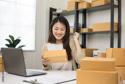 Finished jobs. Happy asian woman entrepreneur working with laptop Deliver parcels to customers successfully. Achieved sales as planned. Startup Small business entrepreneur work at home concept.