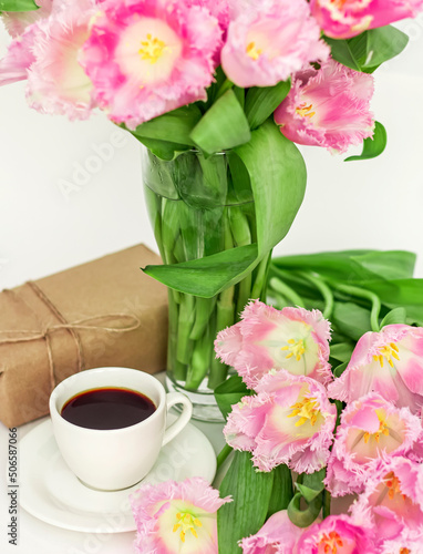 A cup of coffee with a gift and tulips, A gift for a woman on Mother's Day close-up