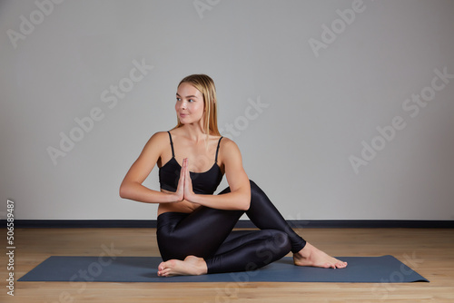 Young yogi woman practicing yoga concept, doing One Legged King Pigeon exercise, Eka Pada Rajakapotasana pose