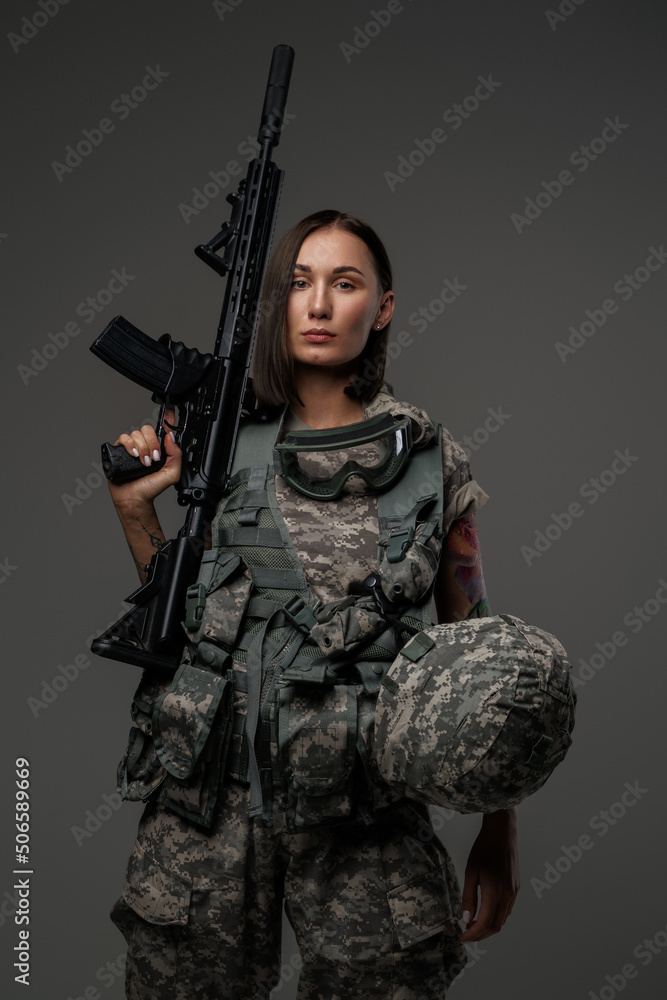 Shot of militant woman dressed in camouflage protective uniform looking at camera. Shot of militant woman dressed in camouflage protective uniform looking at camera.