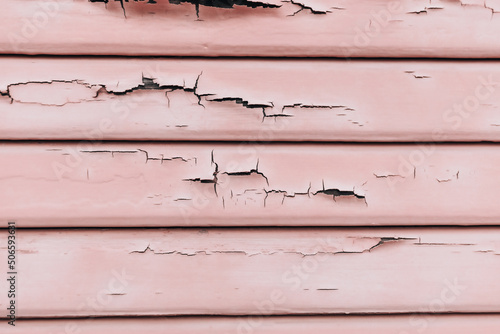 Textured wainscoting wall paneling with chipped and cracked paint chips falling off.