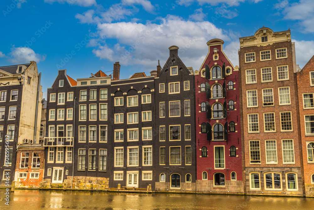 Obraz premium Amsterdam, Netherlands, May 2022. The dancing houses on the Damrak in Amsterdam.