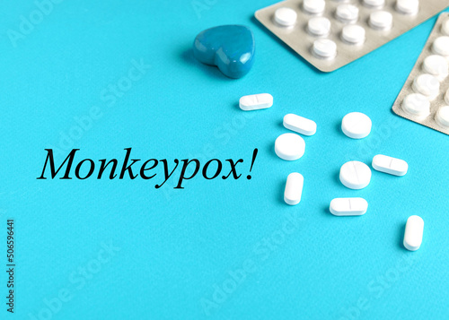 The inscription Monkeypox virus on a blue background, banner. Medical concept, background with scattered pills, blood sample tubes for virus test and and the inscription "Monkeypox virus".