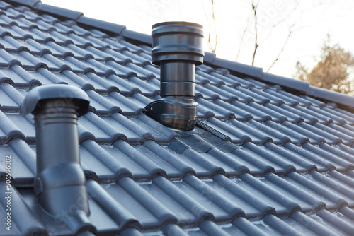 Fotobehang Ventilation pipe and chimney on the roof of a new house