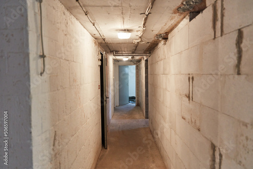 Narrow corridor in the basement with light