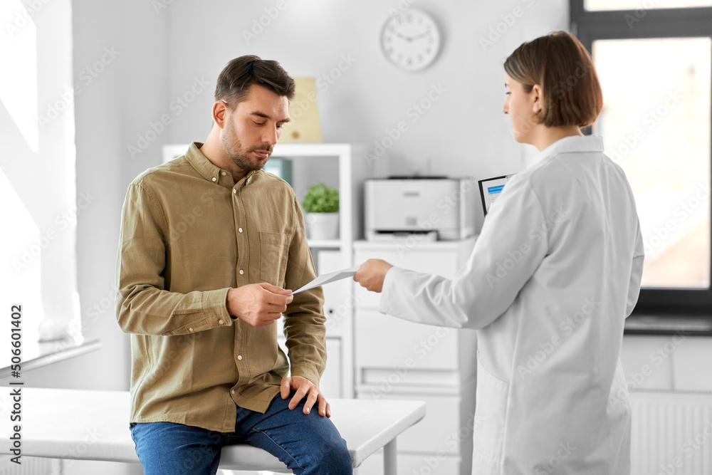 Obraz premium medicine, healthcare and people concept - female doctor giving prescription to man patient at hospital