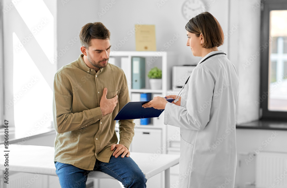 Obraz premium medicine, healthcare and people concept - female doctor showing clipboard to male patient at hospital