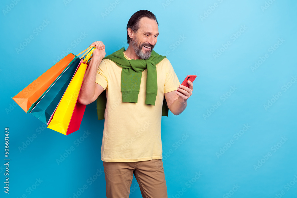 Portrait of funny excited person use telephone read hold packages isolated on blue color background Portrait of funny excited person use telephone read hold packages isolated on blue color background