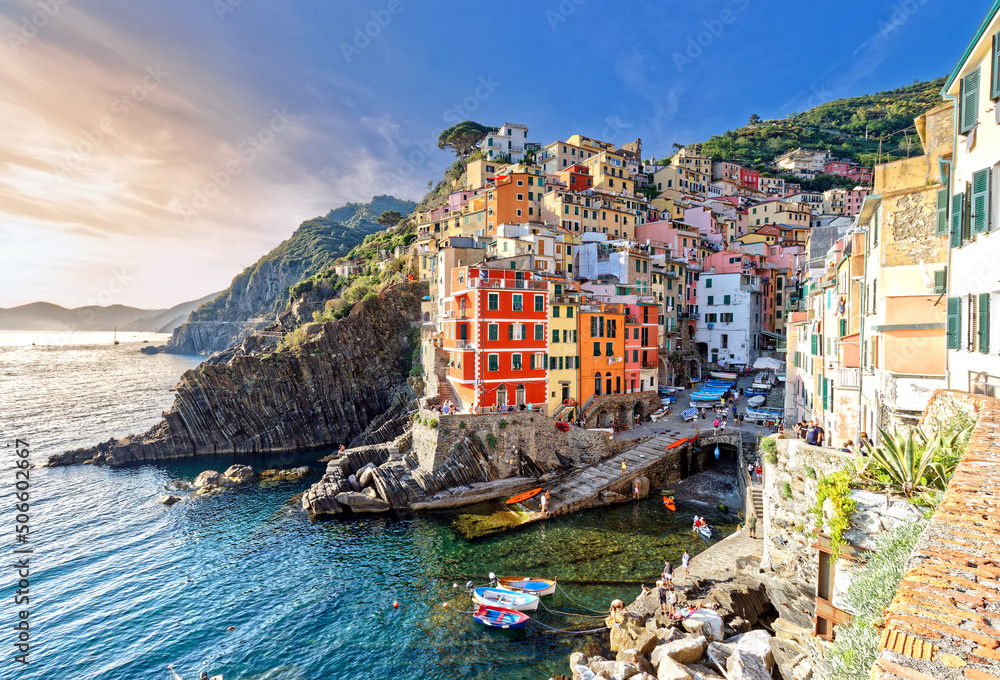 Riomaggiore, Liguria, Italy - June 25, 2021: sunset summer view of the famous touristic village of the Cinque Terre and its sharp cliffs