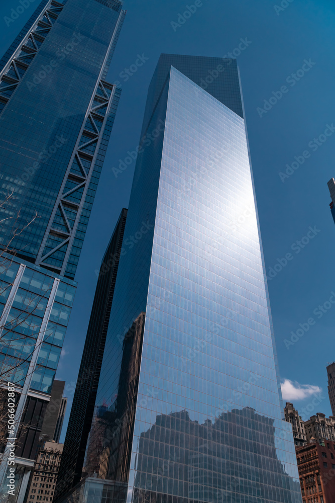 New York City, USA, 2019: Skyscrapers of downtown, bottom view with blue sky on sunny day