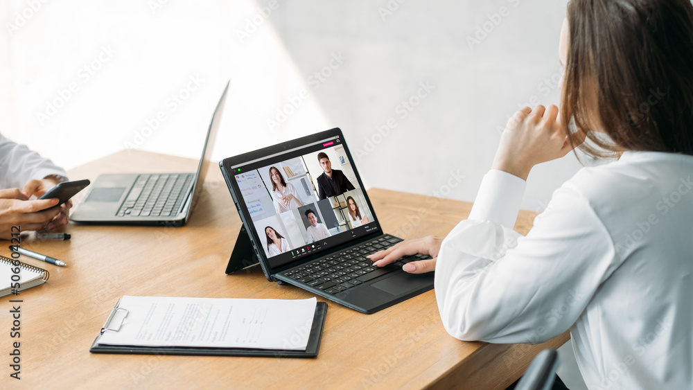 Video presentation. Office routine. Web conference. Female employee working online with professional business team on laptop screen at workplace. Video presentation. Office routine. Web conference. Female employee working online with professional business team on laptop screen at workplace.