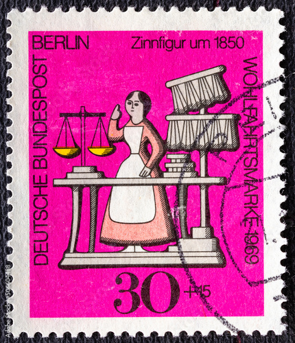 GERMANY, Berlin - CIRCA 1969: a postage stamp from Germany, Berlin showing a charity postal stamp from 1969 with a saleswoman in an antique shop as a tin figure from 1850, circa 1969