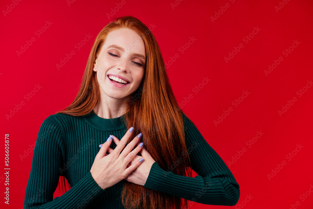 Naklejka premium happy redhair ginger woman in studio background feeling heart thanks