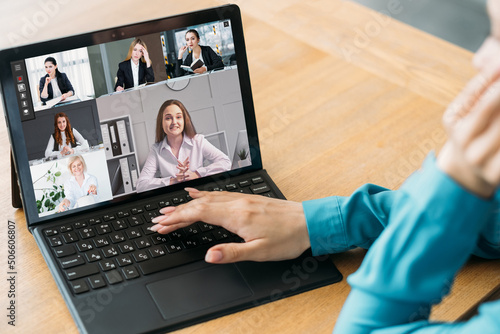 Business teleconference. Remote meeting. Virtual presentation. Female CEO using laptop to work online with team on screen in digital office.