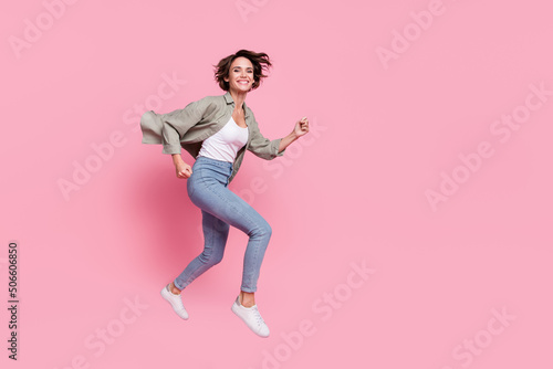 Full body profile side photo of young cheerful girl run hurry fast discount jump up isolated over pink color background