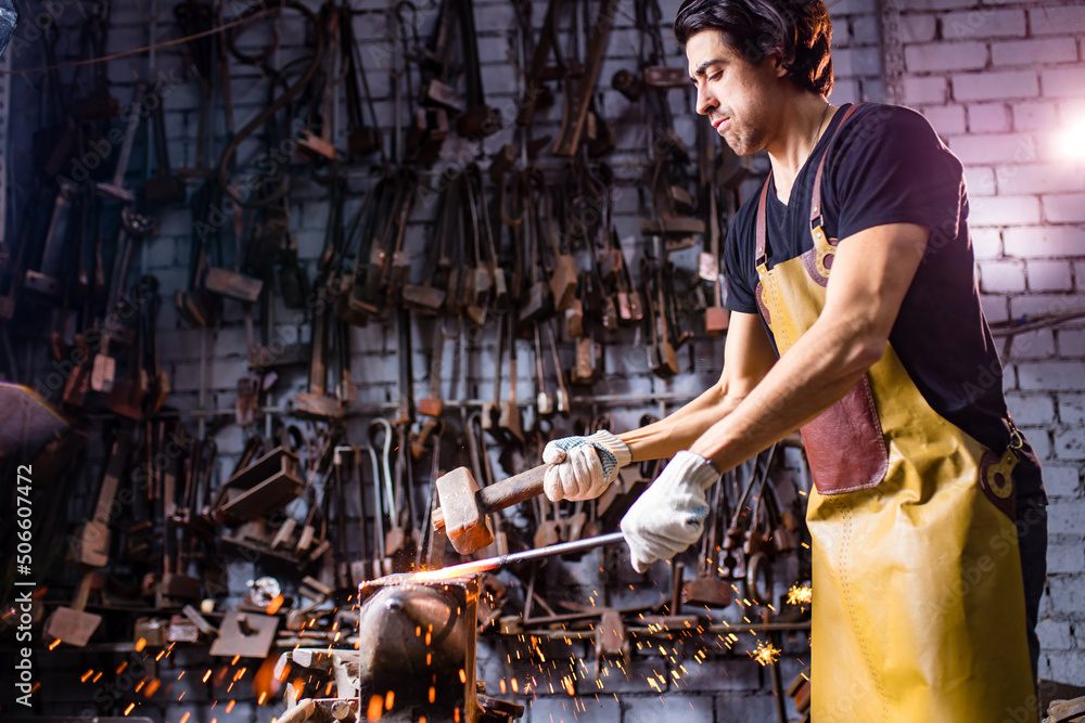 italian brunette man blacksmith working in the workshop