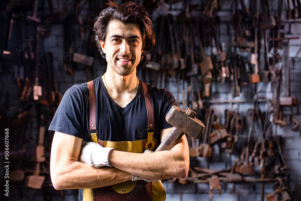 Authentic handsome indian man in leathern apron hammer industry small business Authentic handsome indian man in leathern apron hammer industry small business