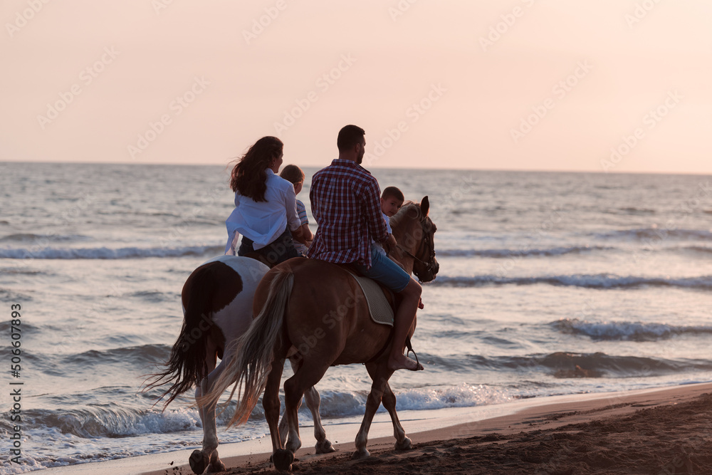 The family spends time with their children while riding horses together on a sandy beach. Selective focus The family spends time with their children while riding horses together on a sandy beach. Selective focus